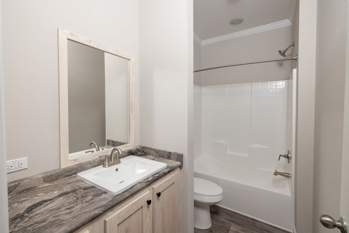 e0aa2b4b-14f3-40e7-a01a-42042fe9ef9f A bathroom with a sink, toilet and shower.