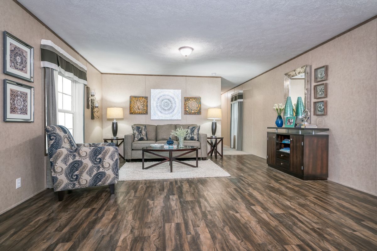 A living room in a mobile home with hardwood floors.