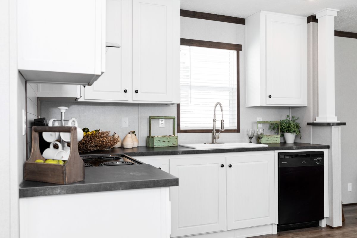 A kitchen with white cabinets and black appliances.
