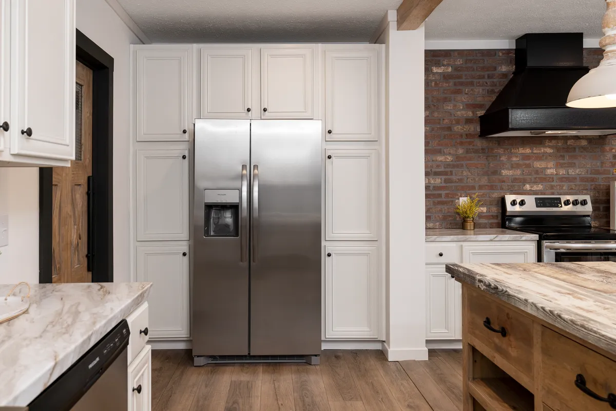 e81e2e6f-917e-4ba6-8e70-e29fd53c63a4 A kitchen with white cabinets and a stainless steel refrigerator.