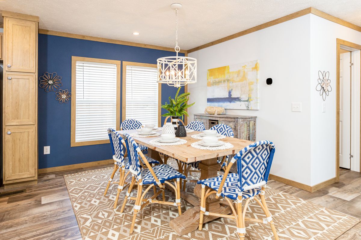 A dining room with blue walls and a wooden table.