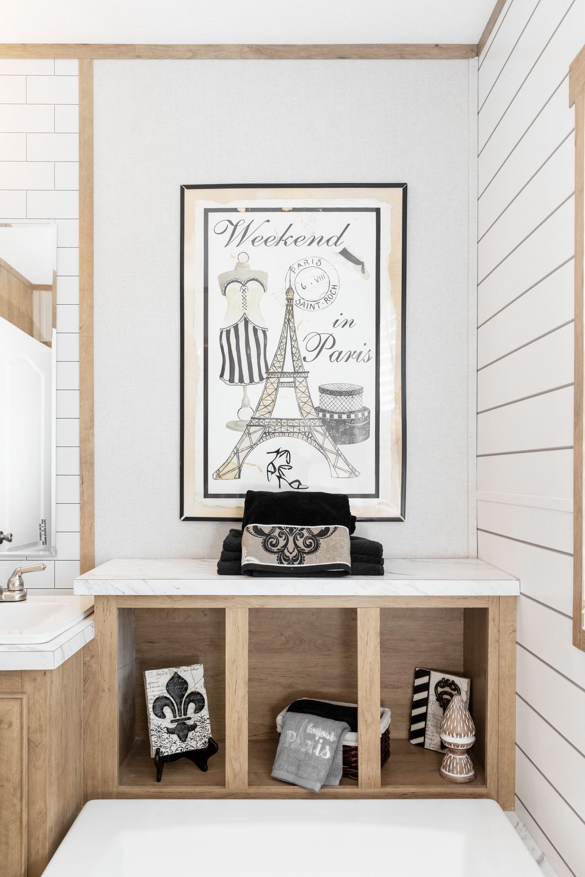 e935ab4a-8afa-4a87-84e0-ea4e3b874b0c A bathroom with an eiffel tower print on the wall.
