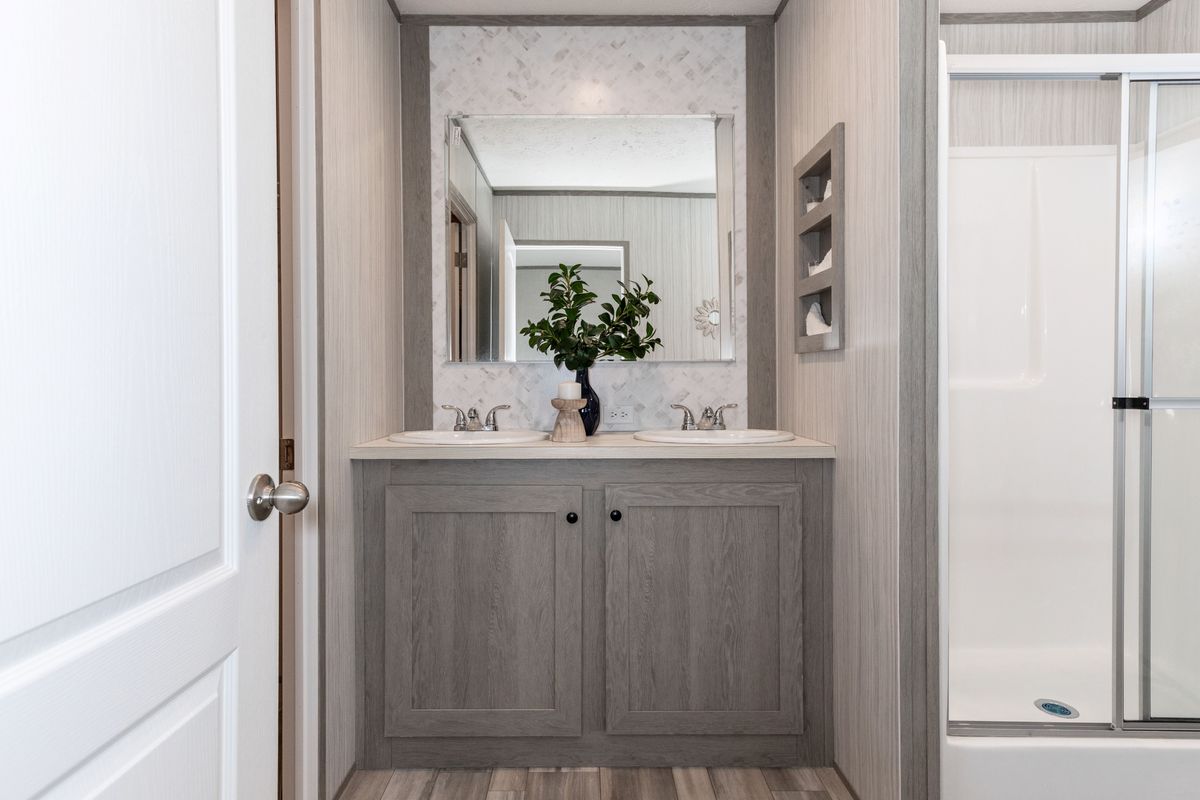 ea066e46-44d1-463c-85e5-c7d2a99a3159 A bathroom with a shower and sink in a mobile home.