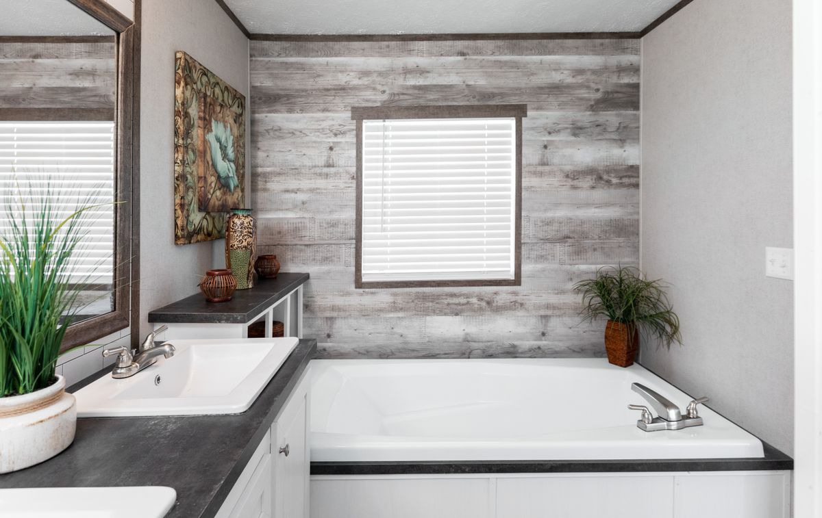 A bathroom with a tub and sink in a mobile home.