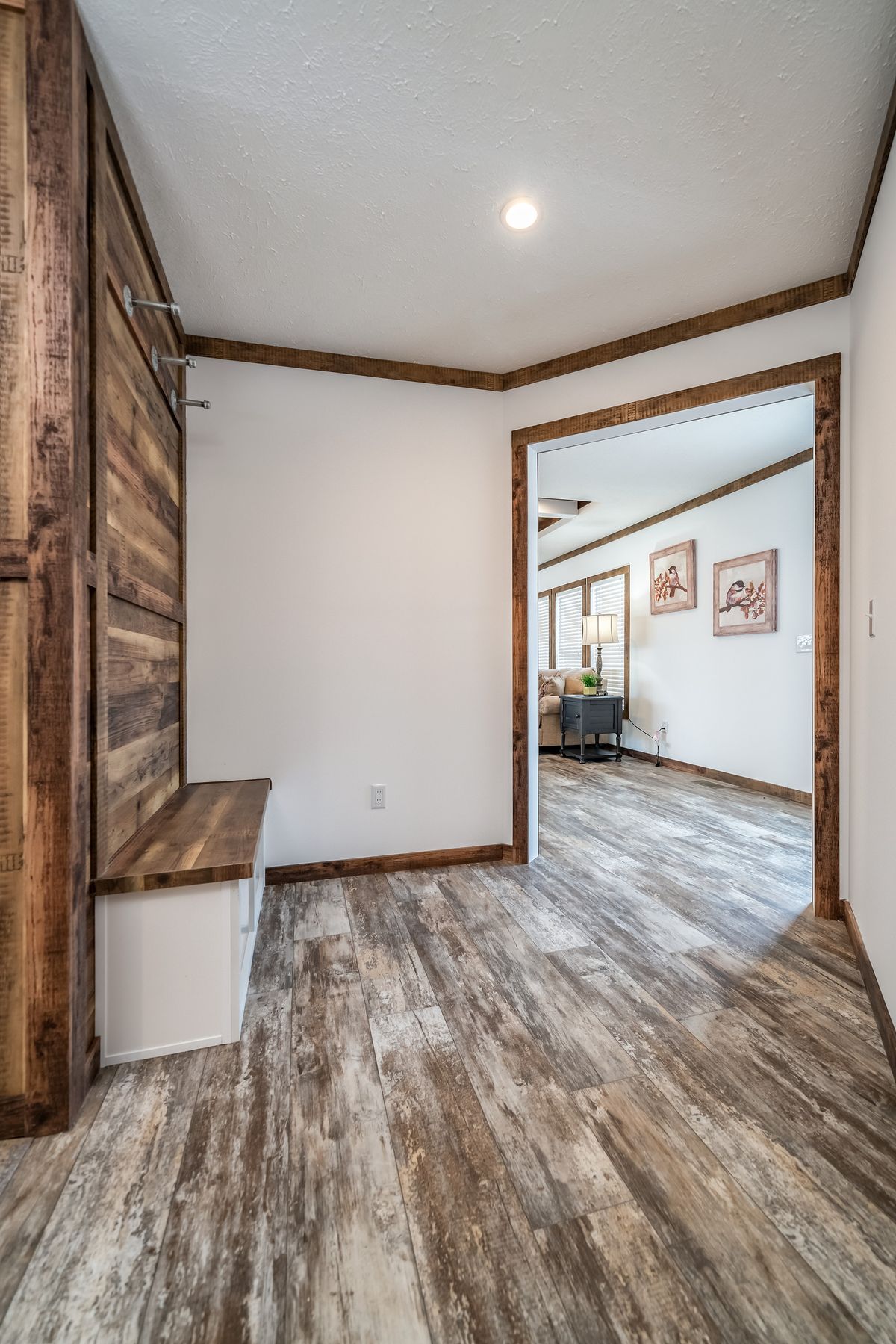 A living room with wood floors and a wooden bench.