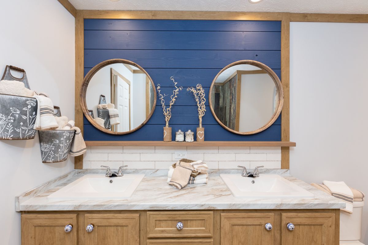 A bathroom with blue walls and two sinks.