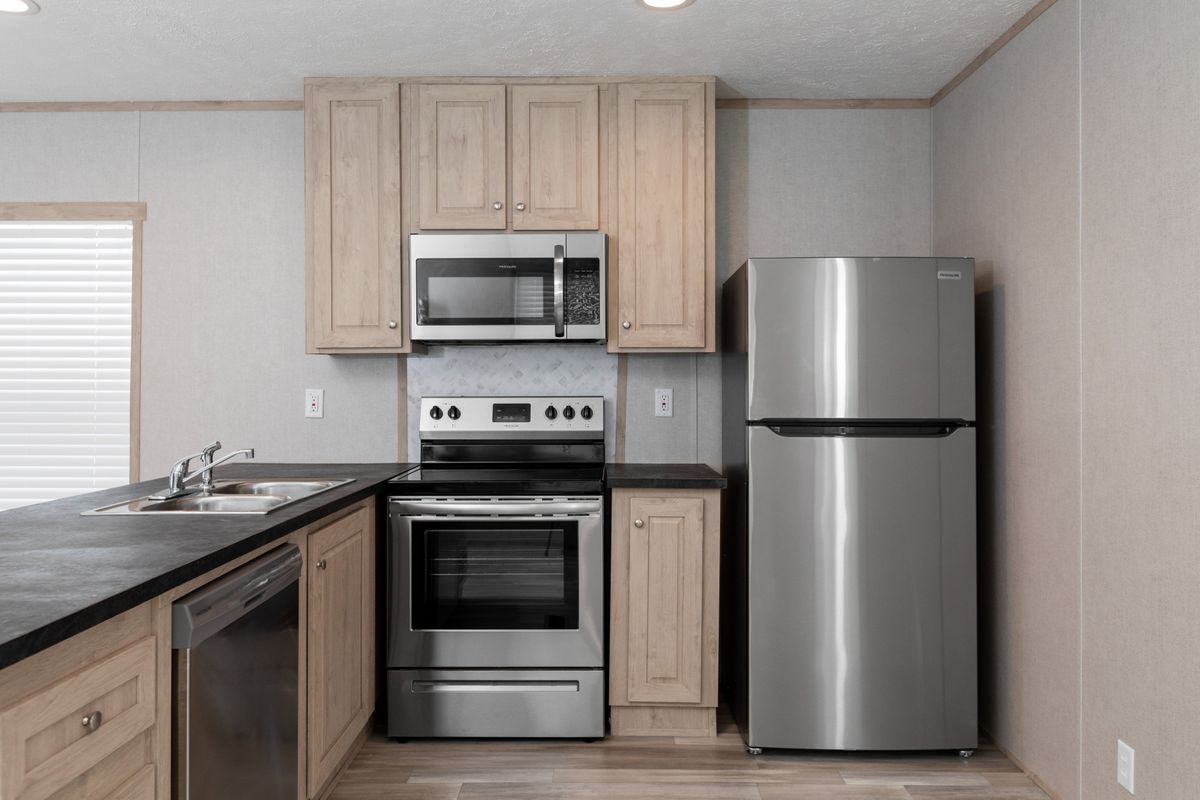 ed34dc54-2a1b-4c9d-9698-b60d77be088f A kitchen in a mobile home with stainless steel appliances.