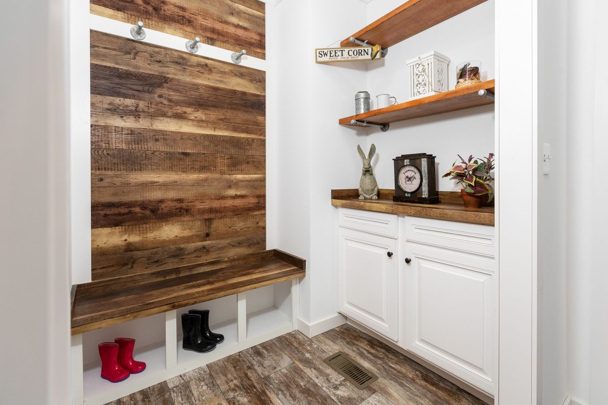 A mudroom with a wooden wall and shelves.