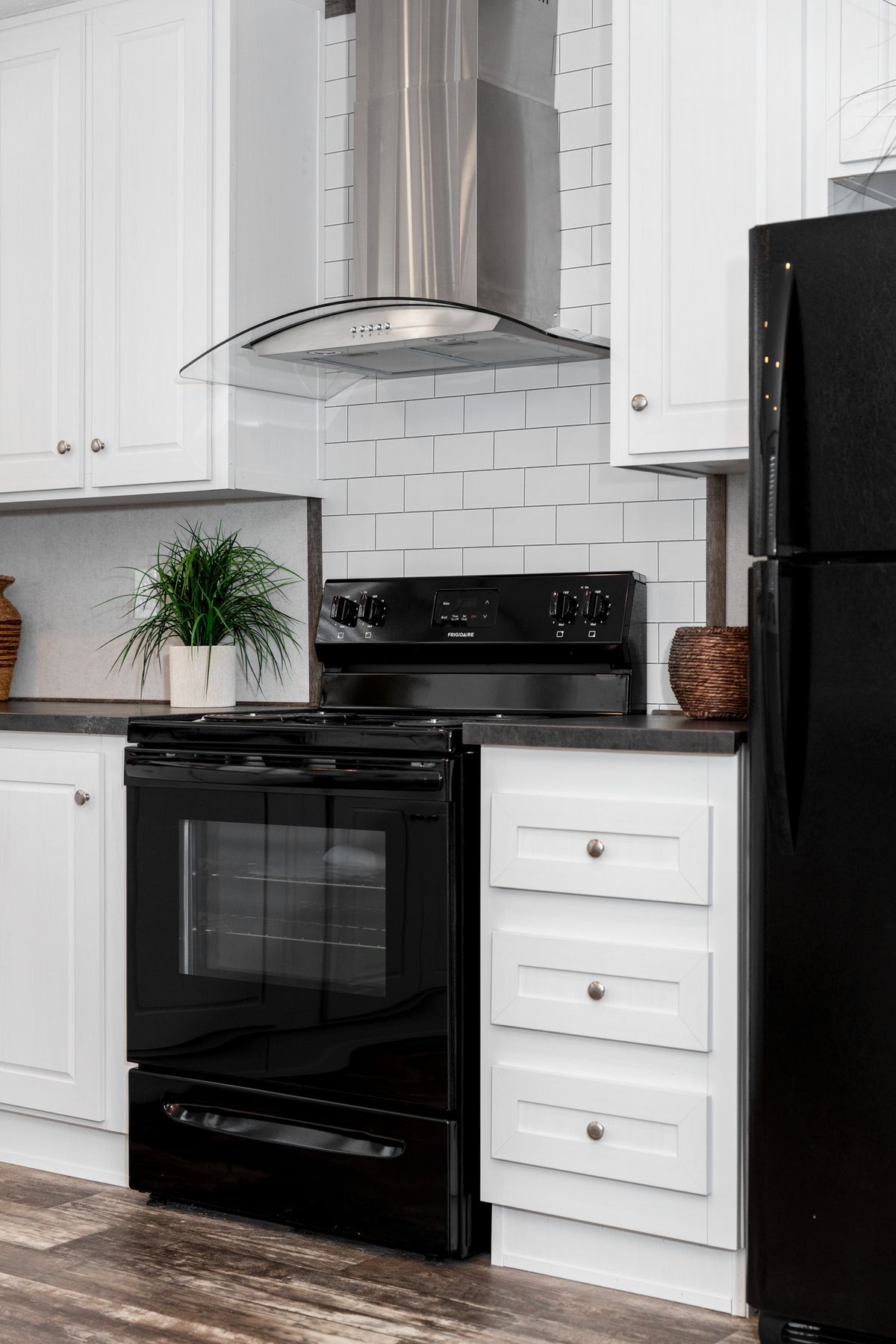 A kitchen with black appliances and white cabinets.