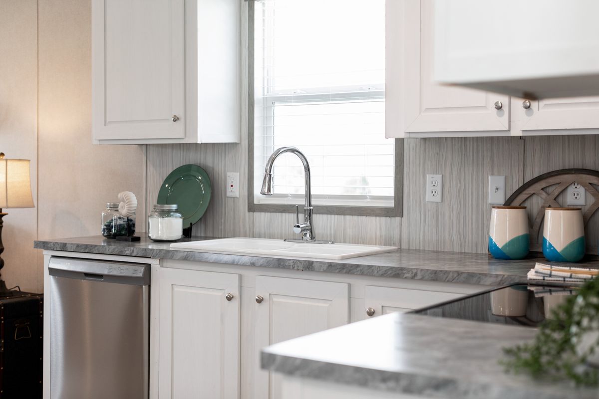 ef945052-4536-484c-8806-783f73dffb5f A kitchen with white cabinets and stainless steel appliances.