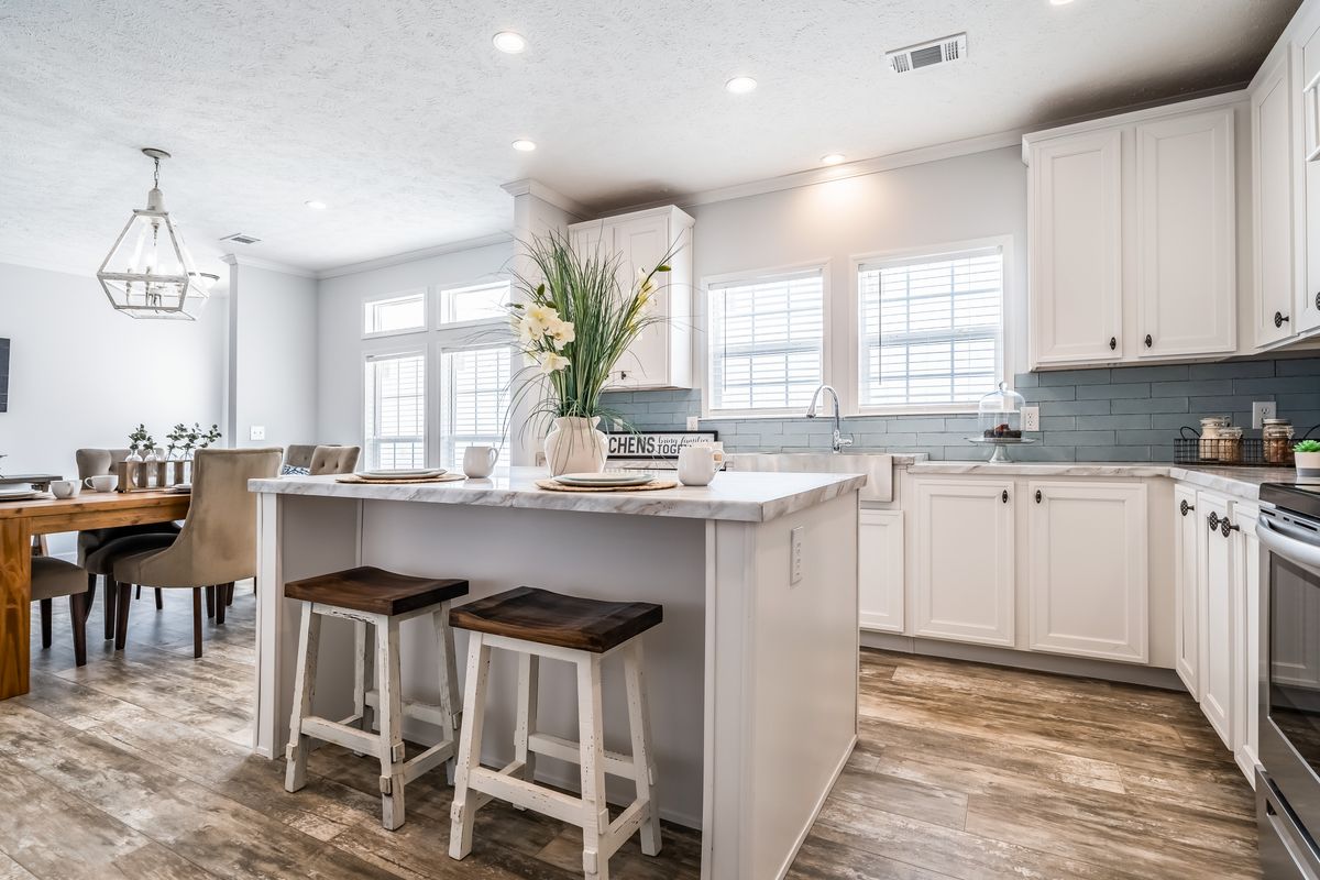 f0445a94-8ca6-446c-99fa-1c0fcfc5a7fb A kitchen with white cabinets and hardwood floors.