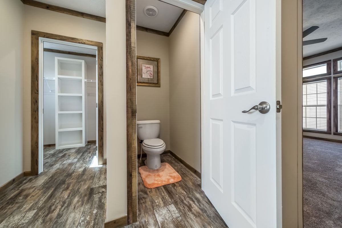 A bathroom with wood floors and a toilet.