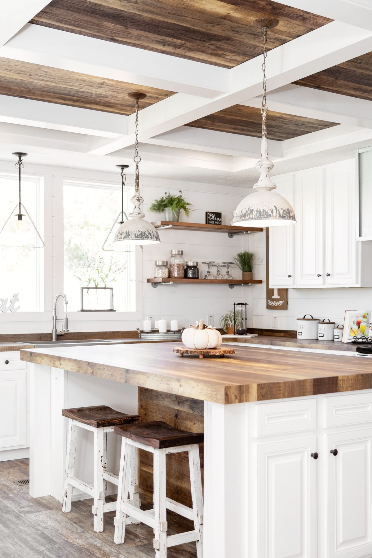 A white and wood kitchen with a center island.