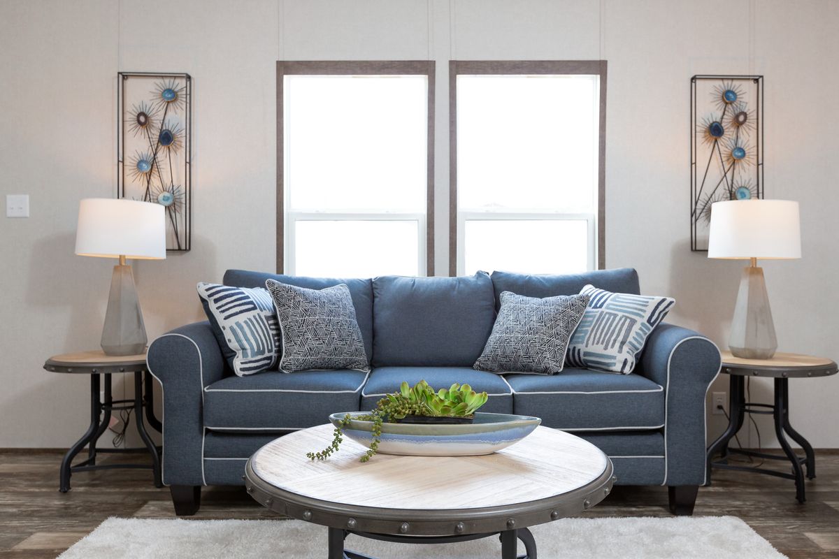 f40169dc-073e-470d-8a29-53f28ea1b9b4 A living room with a blue couch and a coffee table.
