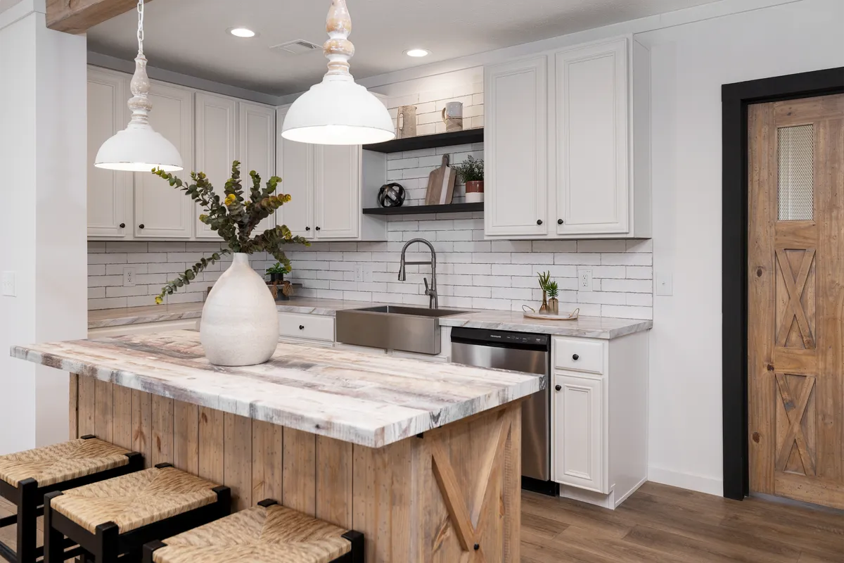 f4c0239e-9102-4488-97ee-43fd1d7e2866 A kitchen with white cabinets and wood stools.