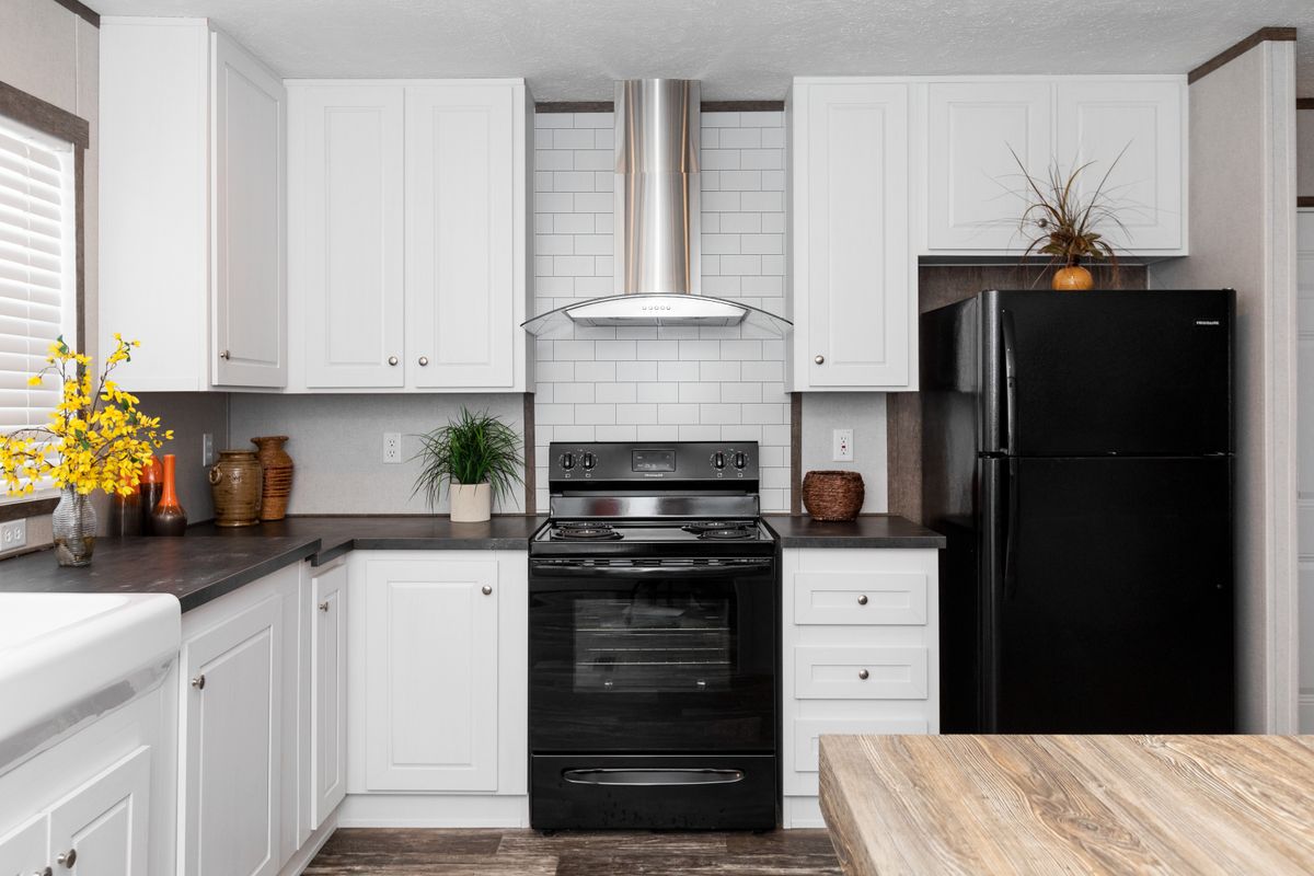 A kitchen with white cabinets and black appliances.