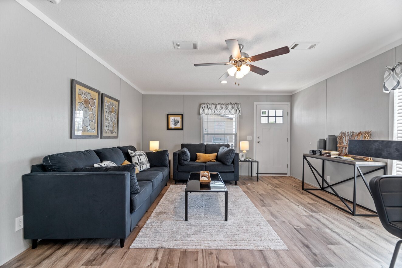 the_clarke_52769981324_o_1679953618995_1323_12 A living room with hardwood floors and a ceiling fan.