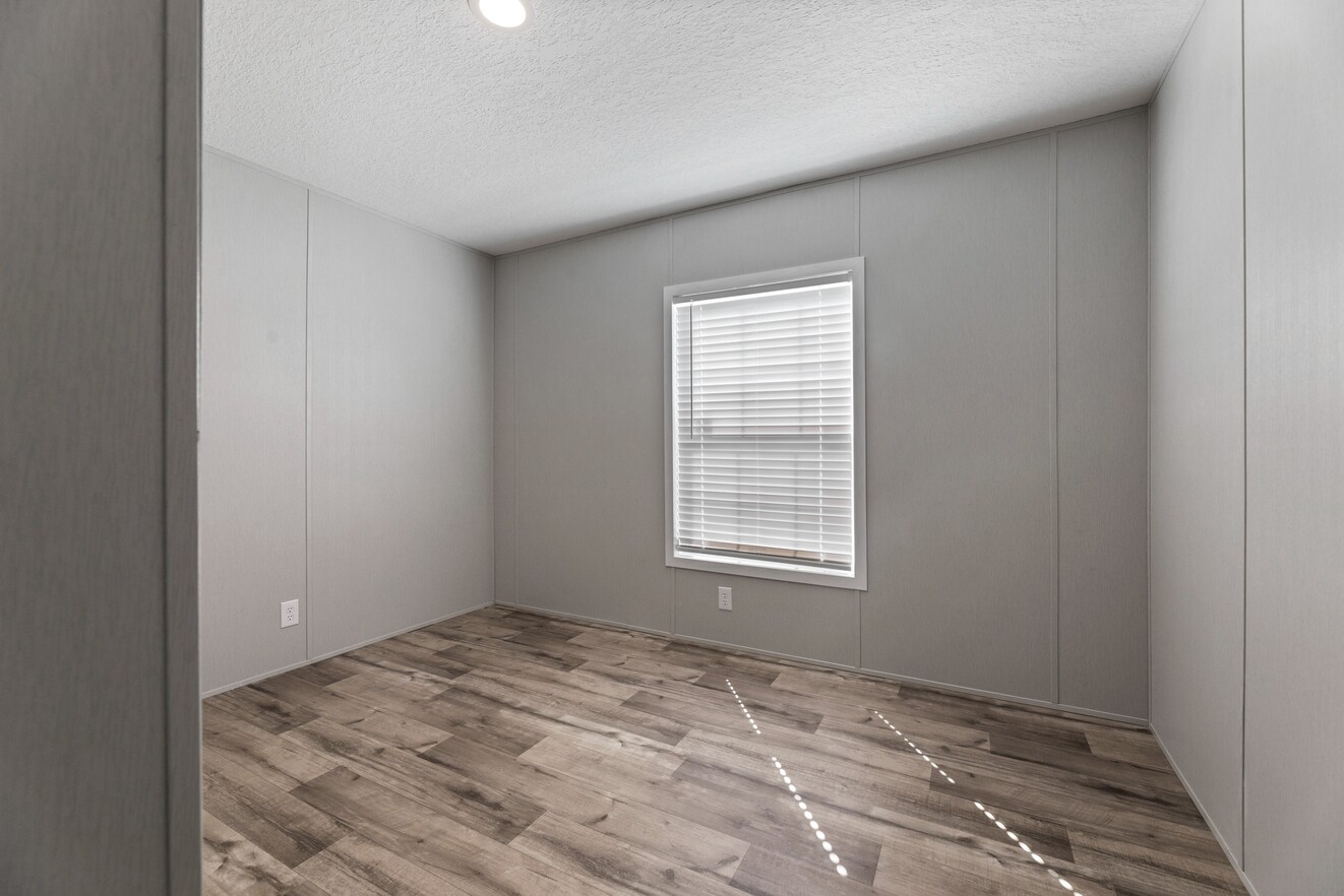 the_clarke_52770214483_o_1679953463809_1323_12 An empty room with wood floors and a window.