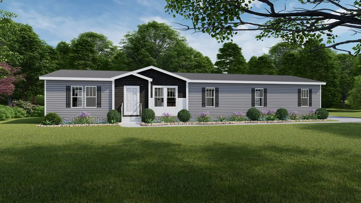 3052a345-d232-45b2-ae0e-8e8cf554f407 A modern gray modular home with white trim, surrounded by a manicured lawn and flower beds, set against a backdrop of lush trees.