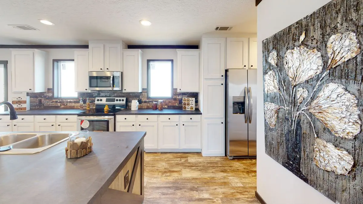 54bfe436-4da5-47cd-b509-ac9ee3fee346 Modern kitchen with white cabinets, stainless steel appliances, and a large floral art piece on the right wall.