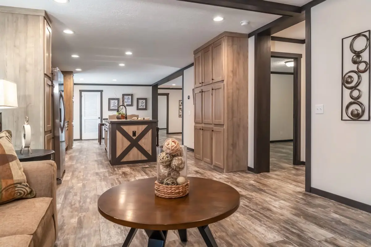 Modern living room with wooden furniture, decorative wall art, and a round table with a basket centerpiece.