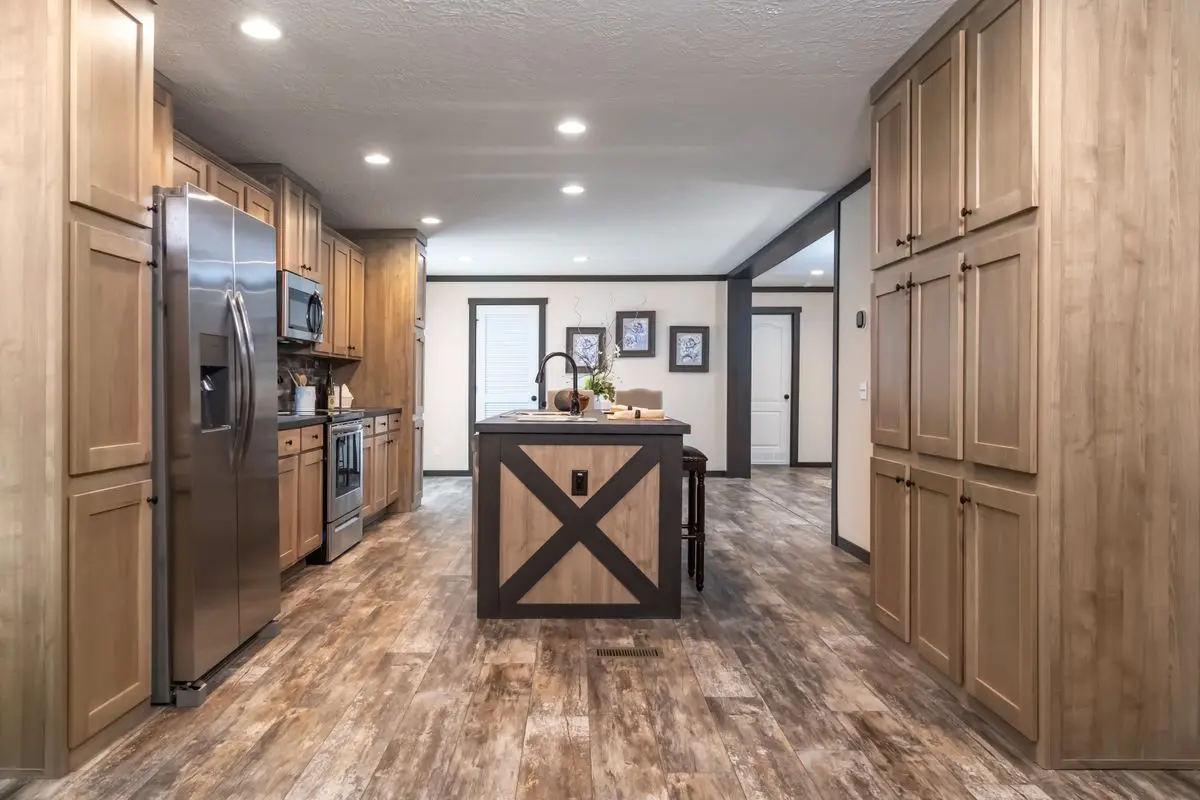 Modern kitchen interior with wooden cabinets, stainless steel appliances, an island, and hardwood flooring.