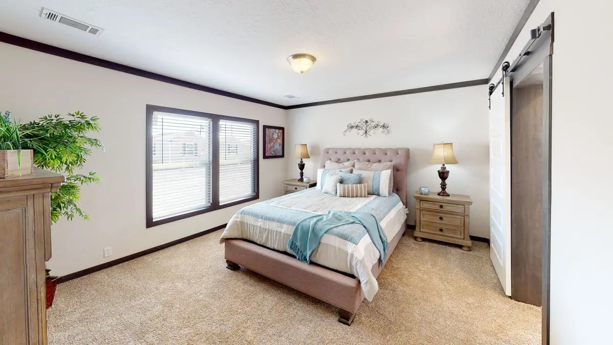 b6833757-07f5-4aa1-a8e0-b99f5a076e14 A modern bedroom featuring a large bed with a tufted headboard, wooden nightstands, a sliding barn door, and a decorative plant near a window.