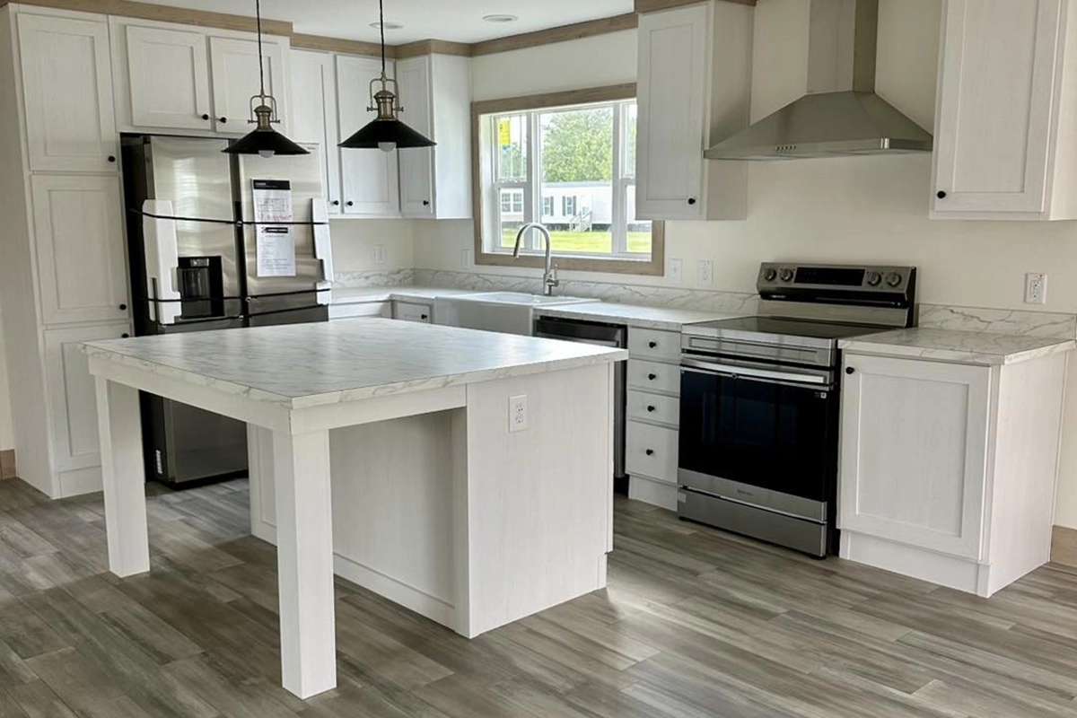 Modern kitchen with white cabinets, marble countertops, stainless steel appliances, a central island, pendant lights, and wood-look flooring.