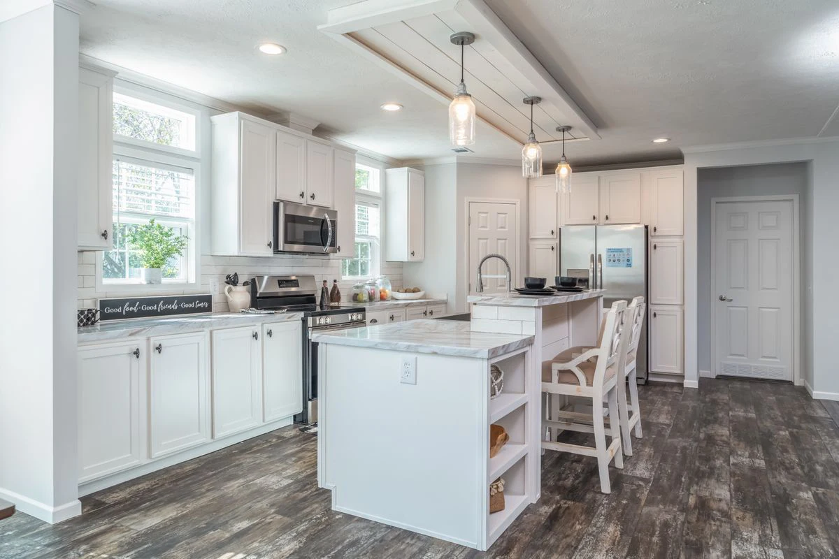 Bright, modern kitchen with white cabinets, stainless steel appliances, a center island with seating, pendant lighting, and wood-look flooring.