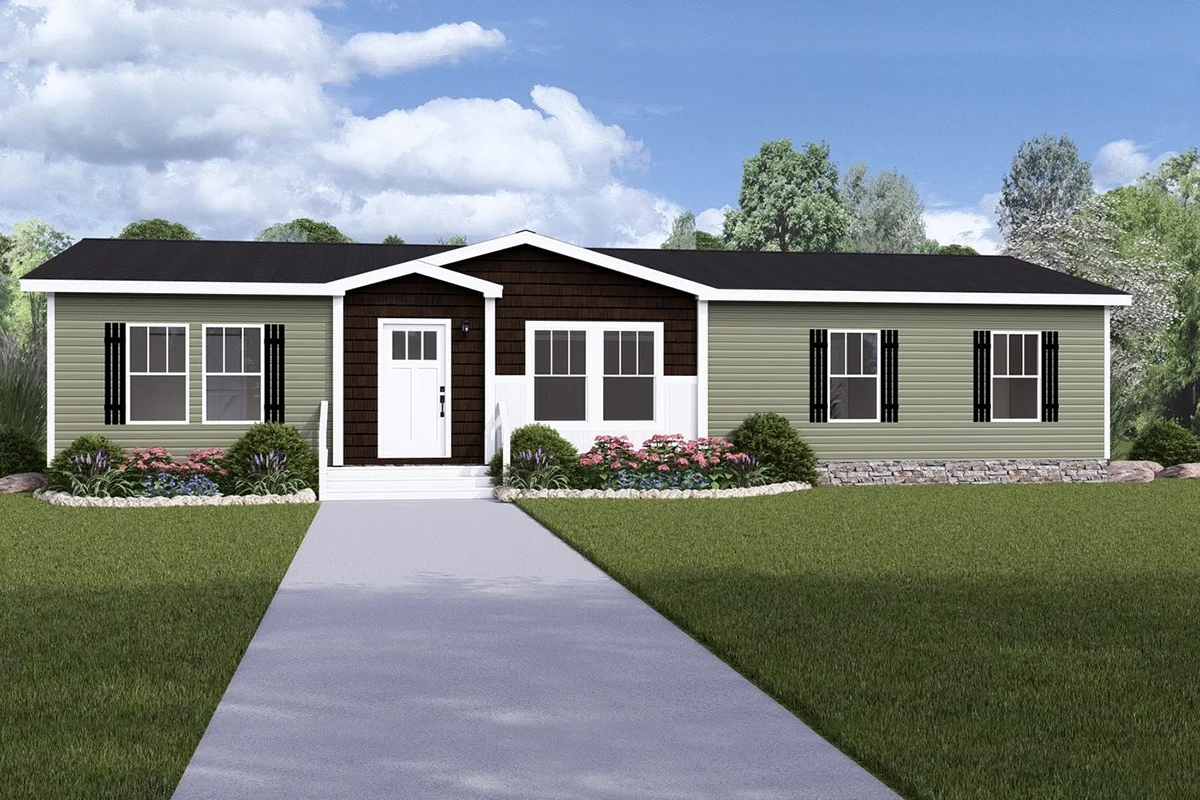 A single-story manufactured home with green siding, black shutters, white trim, a front porch, landscaped bushes, and a concrete walkway leading to the entrance.