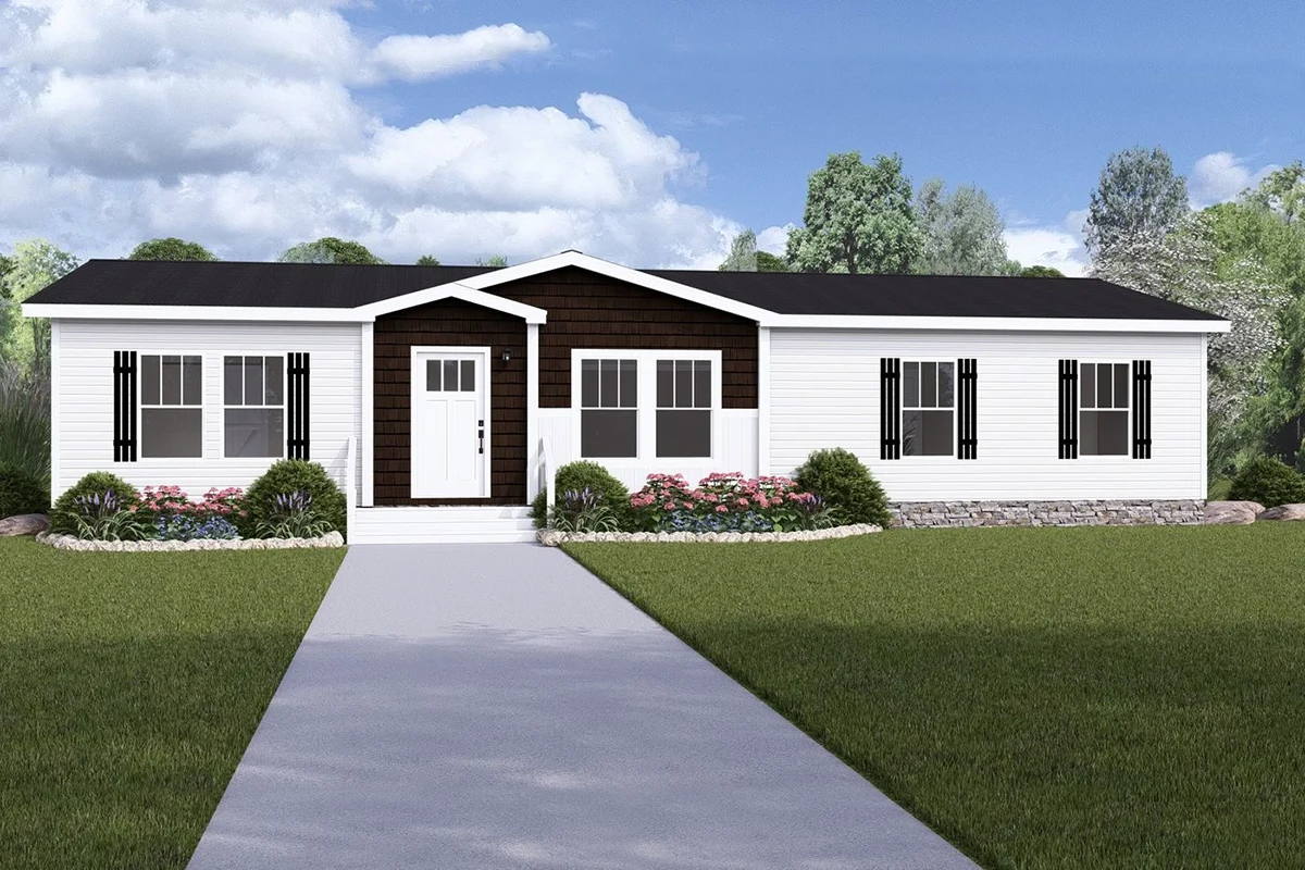 A single-story manufactured home with white siding, black shutters, a central front porch, and a paved walkway, surrounded by grass and landscaping, with trees in the background.