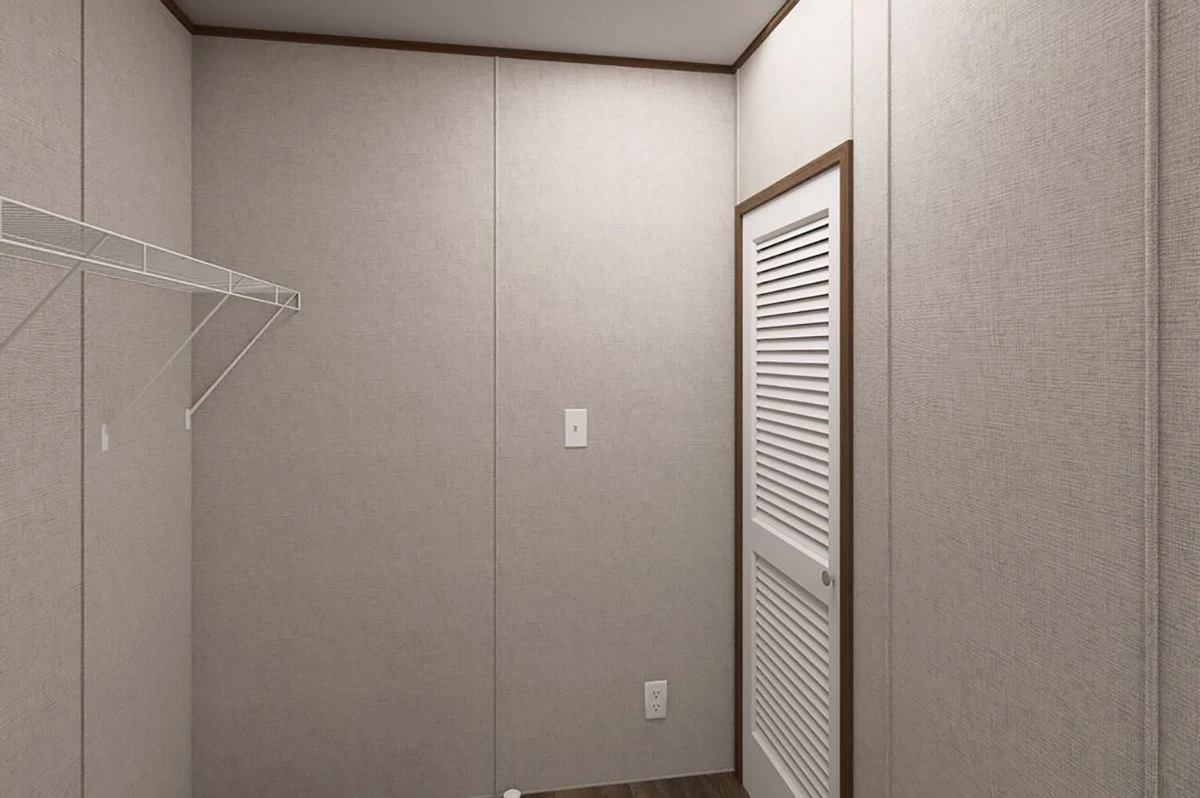 007aeabf-e0b5-4fc9-933e-74bcb4b5e5a3 Empty walk-in closet with beige textured walls, a white wire shelf on the left, a white vented door on the right, and dark wood flooring.