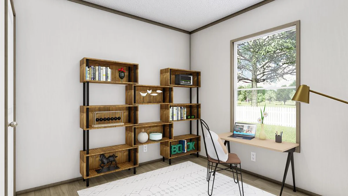 A home office with a wooden bookshelf, a small desk with a laptop, a lamp, a window showing trees and a fence, and a white rug on the floor.