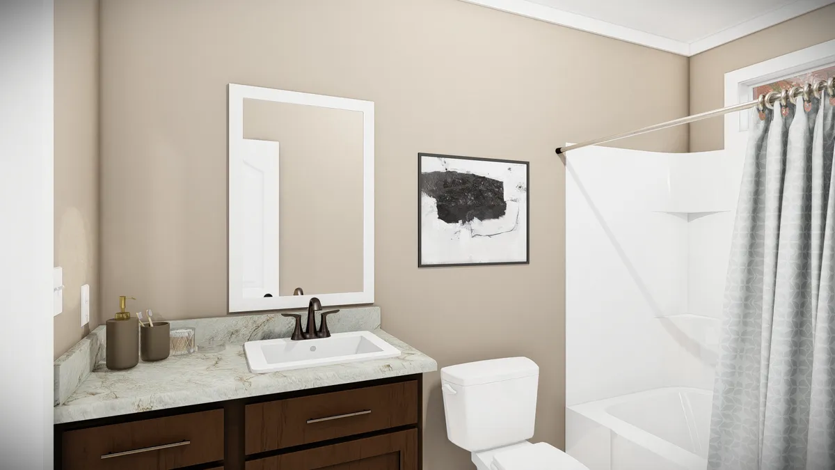 07cfcc13-1284-4c7c-add2-6dddcd693ec1 A bathroom with a sink and dark wood cabinet, a toilet, a shower with a gray curtain, and a framed abstract artwork on a beige wall.