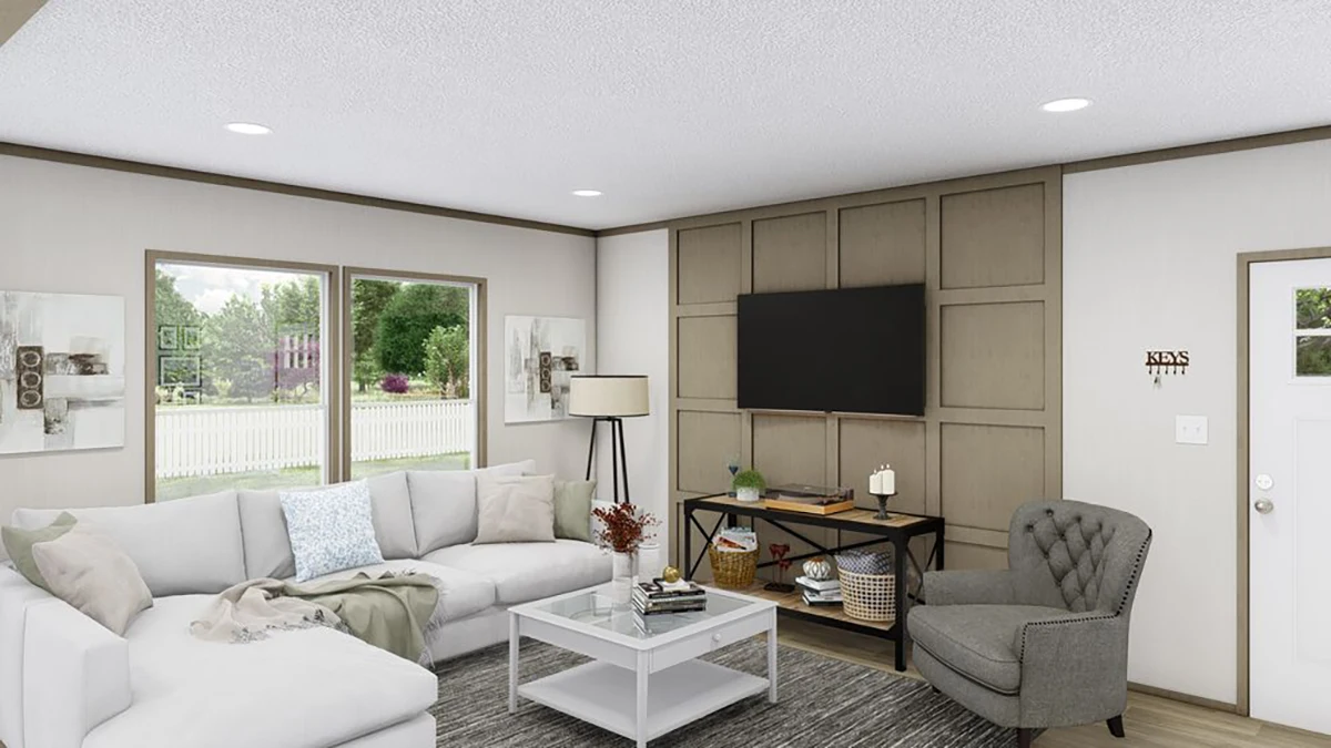 A modern living room with a large sectional sofa, armchair, coffee table, wall-mounted TV, artwork, and windows showing a green yard outside.