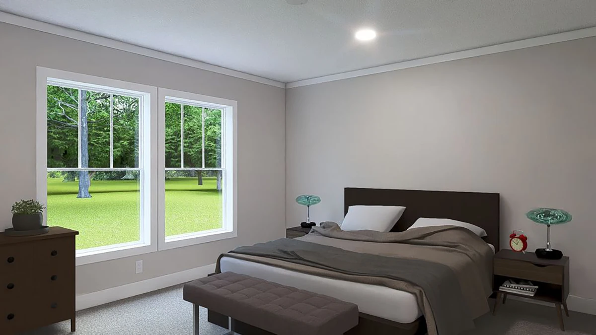 A bedroom with a made bed, two nightstands with lamps, a dresser with a small plant, a bench at the foot of the bed, and two large windows overlooking a green yard.