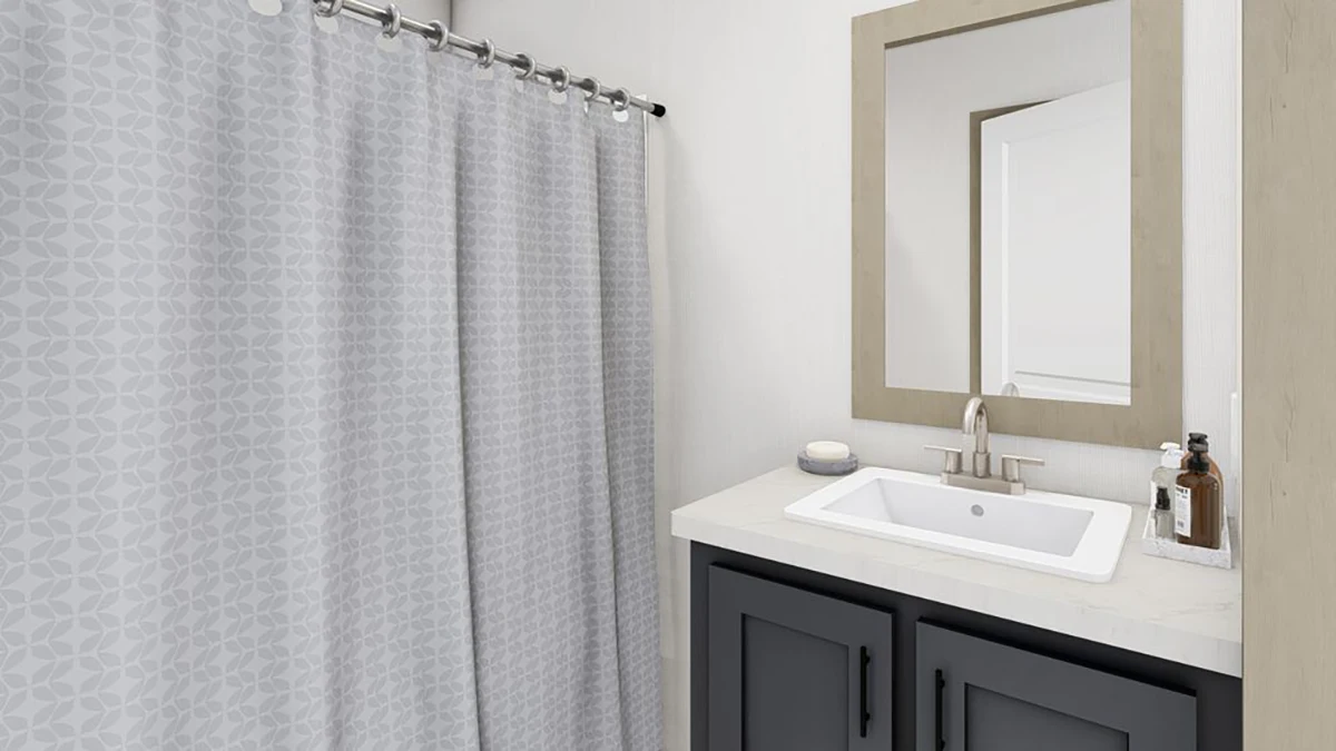 A modern bathroom with a gray geometric shower curtain, a white sink with silver faucet, black vanity cabinets, and a large rectangular mirror above the sink.