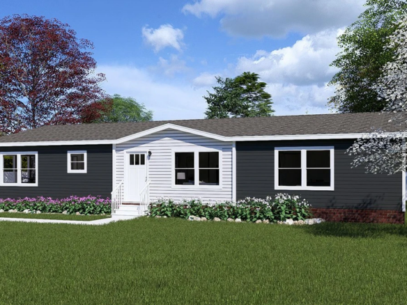 Single-story house with dark siding, white trim, and a gabled entrance. Surrounded by a green lawn, white flowers, and trees under a partly cloudy sky.