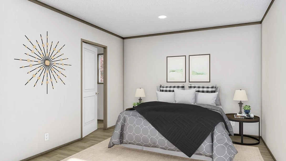 A neatly made bed with patterned bedding and black blanket is centered in a minimal bedroom with two nightstands, lamps, wall art, and a sunburst wall decoration.
