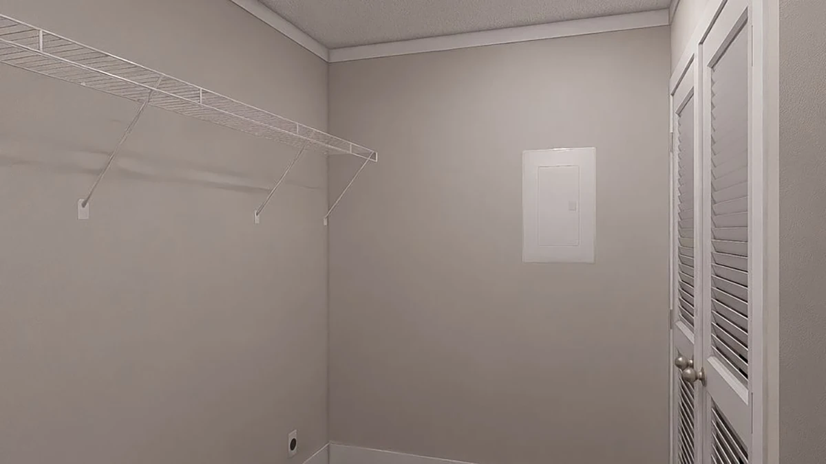 Empty walk-in closet with beige walls, a white wire shelf, a closed louvered door, and an electrical panel on the back wall.