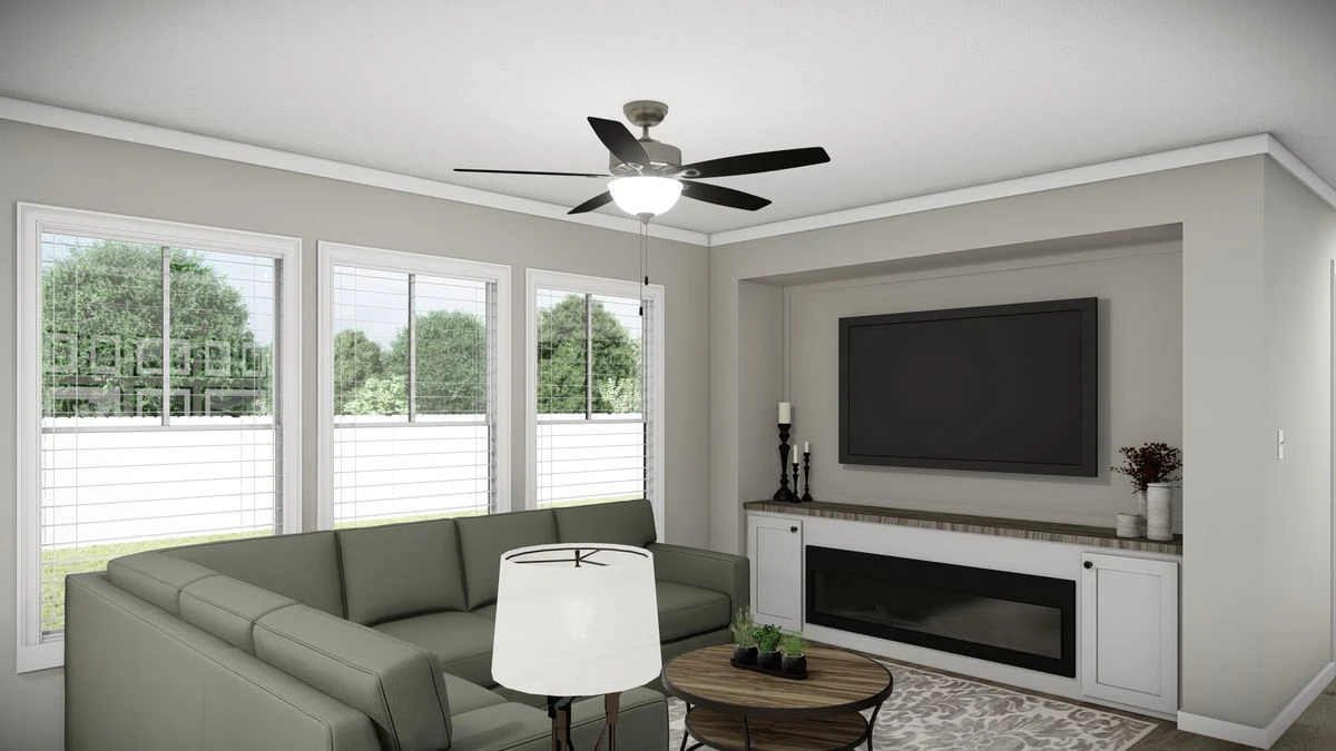 13c2a25a-b70b-4ec6-95b2-c357dc6cf30e A modern living room with a sectional sofa, round coffee table, floor lamp, wall-mounted TV, built-in cabinets, fireplace, and large windows with a view of greenery outside.