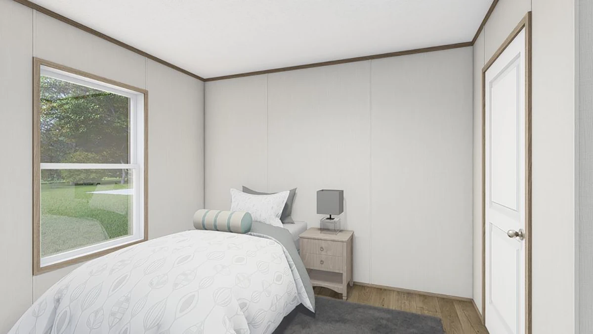 Small bedroom with a single bed, patterned bedding, a nightstand with a lamp, a window with outdoor view, and a closed white door.