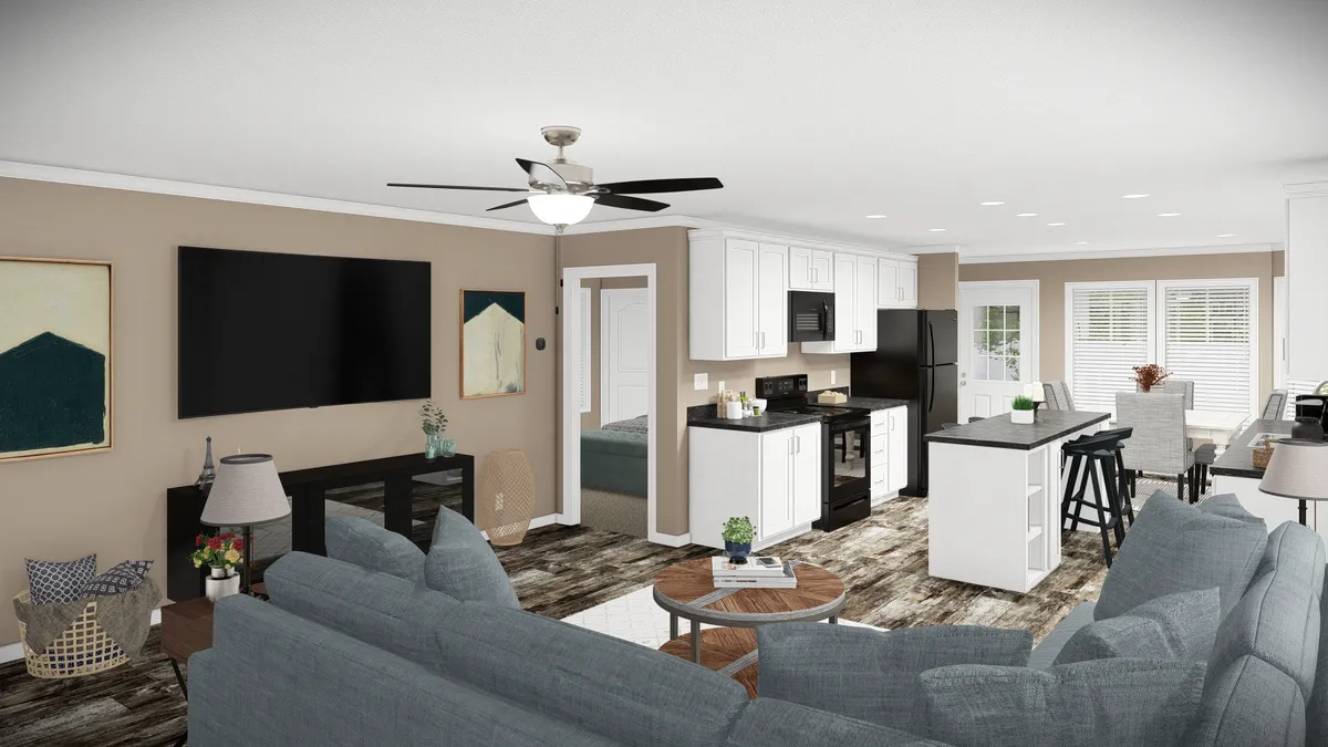 1daa57a2-4bda-4b9e-92c2-14d05e546929 A modern open-plan living area with a gray sectional sofa, wall-mounted TV, kitchen with white cabinets, black appliances, and an island with barstools.