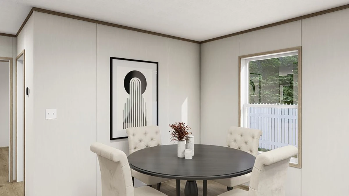 22a64100-d4a2-4b65-bc0c-5788e0c8b6d3 A round dining table with four upholstered chairs, a vase with dried flowers, wall art, and a window showing a white fence and greenery outside.