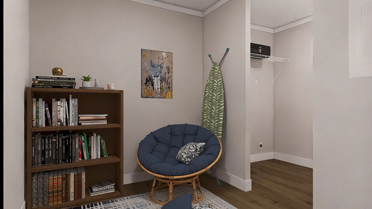 A small room with a bookshelf, a round cushioned chair, a patterned blanket on a stand, a wall painting, and an open closet with a shelf and box.
