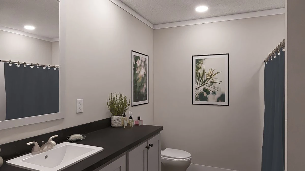 276c534f-a6f6-4552-877d-bbd49d079600 A modern bathroom with a sink, countertop, mirror, toilet, blue shower curtain, two framed botanical prints, and various toiletries on the counter.