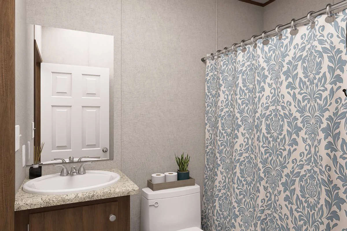 295f3178-285e-449b-a0f6-b7af419c2233 A bathroom with a sink and mirror, a toilet with plants and tissue boxes on top, and a blue patterned shower curtain.