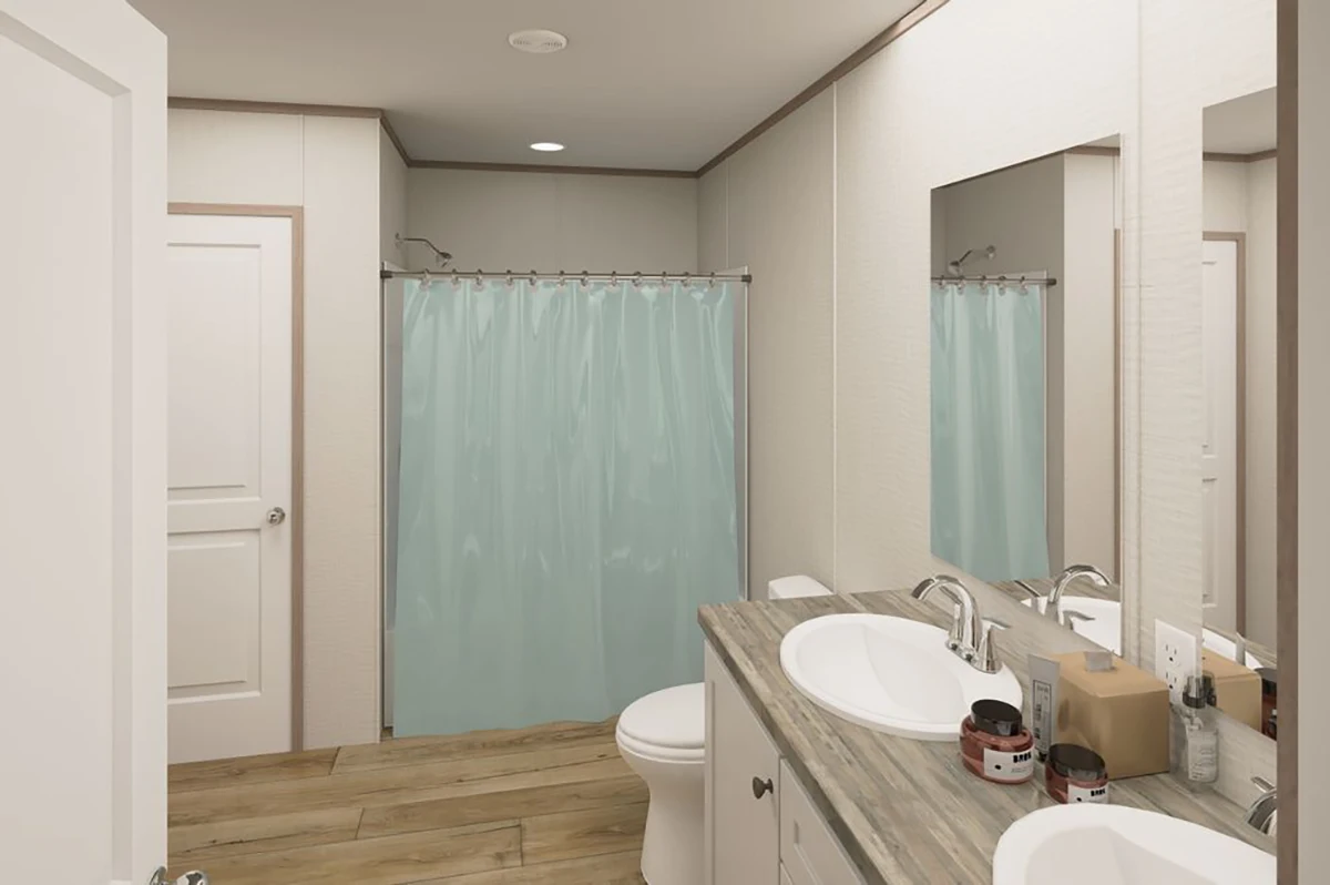 A modern bathroom with a double sink vanity, large mirror, toilet, and a shower with a light blue curtain. The floor is wood-patterned, and toiletries are on the counter.