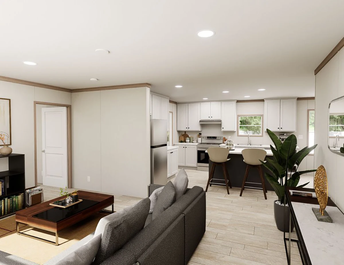 Open-concept living area with a gray sofa, coffee table, indoor plant, and a kitchen with white cabinets, stainless steel appliances, and a breakfast bar with two stools.