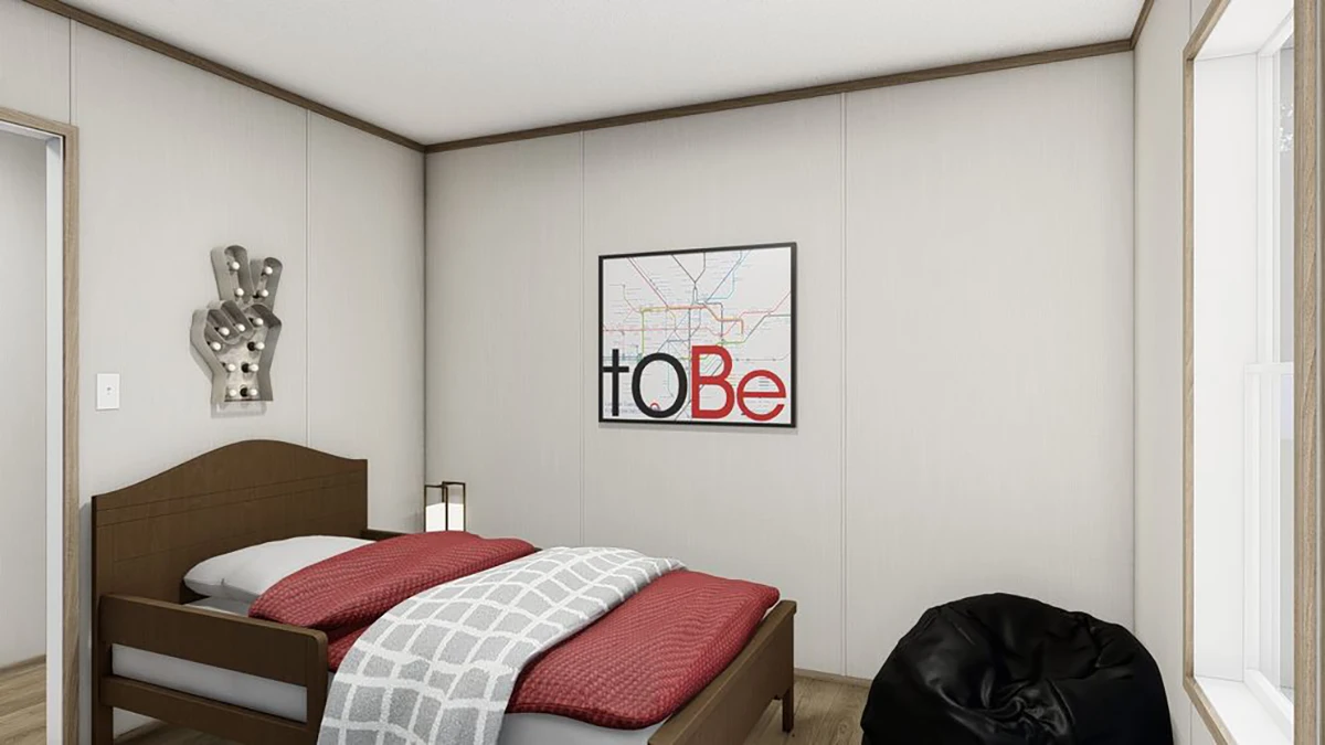 A small bedroom with a single bed, red and gray bedding, a bean bag chair, and a wall art print that reads "to Be." A metal hand-shaped decor hangs beside the bed.
